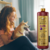 Mulher acariciando um cachorro com um frasco de shampoo tonalizante Ametista Cereja e Avelã ao lado.