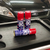 Três latas de descarbonizante Car80 em uma bancada de oficina, com um carro preto ao fundo.