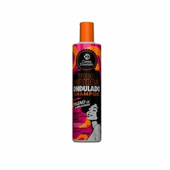 Frasco de shampoo Todo Poderoso Ondulado da marca Corpo Dourado com tampa laranja e rótulo preto e laranja