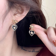 Aretes corazón negro y moño dorado, poste de plata .925