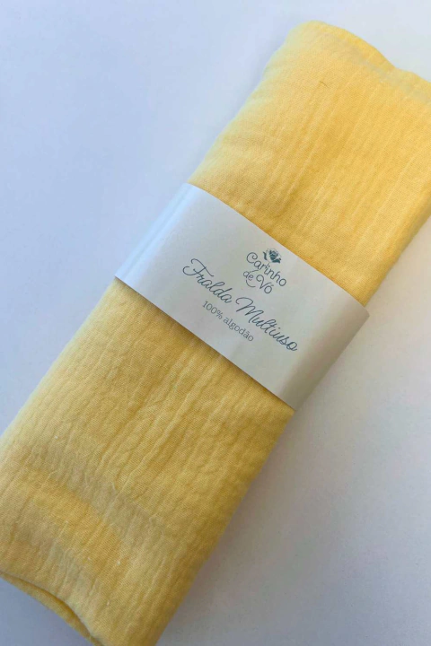 Fralda de musselina amarela Carinho de Vó, 100% algodão, dobrada e embalada com faixa de papel personalizada.
