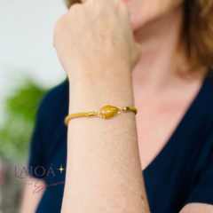 Pulseira cordão com pingente em formato de gota, destacando-se no pulso de uma mulher.