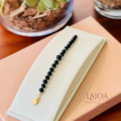 Pulseira de pedras naturais em ônix e hematita e fecho dourado.