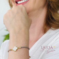 Pulseira Trevo em destaque no pulso de uma mulher.
