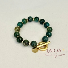 Pulseira de jade verde escura com fecho dourado e detalhes em metal que levam ouro no banho.