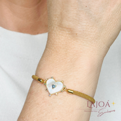 Pulseira Cordão Coração em madrepérolas com detalhes em strass, exibida no pulso.