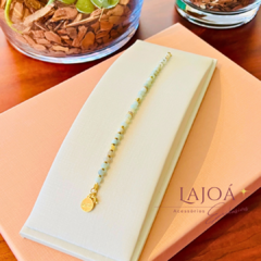 Pulseira delicada com pedras de água marinha e hematita, com detalhe em ouro.