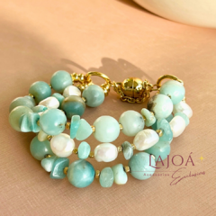 Pulseira tripla com pedras de água marinha e pérolas em tonalidades suaves, com fecho dourado.