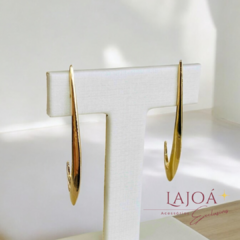 Brinco palito banhado a ouro exibido em suporte branco, destacando seu design elegante.