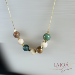 Colar longo com pedras naturais de jade e calcita, com detalhes em banho de ouro.