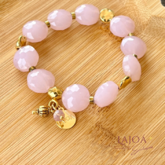 Pulseira de cristal rosa facetado com detalhes em dourado e pingente decorativo.