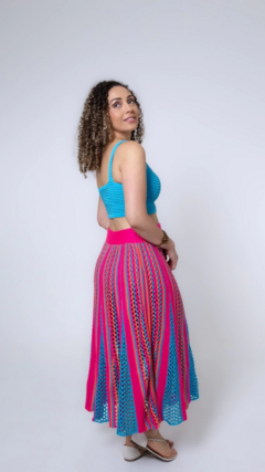 Modelo usando uma saia de tricô Mayra, com cores vibrantes, vista de lado.