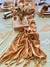 Camino de gasa color terracota sobre una mesa decorada con un arreglo floral, platos y una bandeja de madera.
