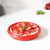 Tartera mini de silicona roja con fresas frescas y crema en su interior.