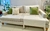 Sillón Kansas Gris con cojines verdes y manta decorativa, ubicado en un ambiente moderno.