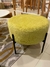 Sillón Puff Marlon de color amarillo con patas negras, situado sobre una alfombra en un ambiente moderno.