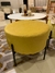 Sillón Puff Marlon de color amarillo, con patas negras, en un ambiente moderno.