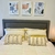 Acolchado blanco suave sobre una cama con almohadas decorativas y cuadros en la pared.