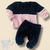 Conjunto de bebê menina com blusa rosa e preta de fleece com pérolas e calça preta.