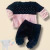 Conjunto de bebê menina com blusa rosa e preta de fleece com pérolas e calça preta.