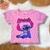 Camiseta infantil rosa com estampa do personagem Stitch sorridente na frente, manga curta com detalhes ondulados