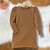 Vestido infantil bege de manga longa com detalhes de pérolas nas mangas e ombros franzidos