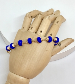 Pulseira dourada com esferas em vidro azul royal