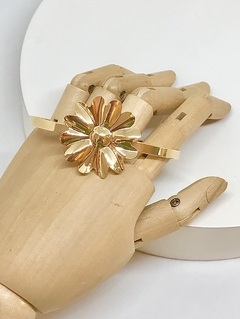 Bracelete dourado semi aberto com flor em metal