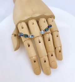 Brinco dourado ear cuff com zircônias em tons de azul na internet