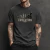 Camiseta preta masculina com estampa da evolução humana que termina em motociclista ao lado de uma motocicleta