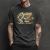Camiseta preta com estampa vintage de moto Indian clássica verde e bege, com detalhes em amarelo e marrom, usada por homem com tatuagens nos braços