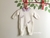 Macacão em tricô maternidade feminino. Saída maternidade para menina. Off white com lilás, com libélulas. Acompanha body com gola.