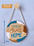 Quadro Decorativo Redondo de Pinus com 18cm pendurado na parede com uma corda de algodão no gancho de pinus, escrito Home Sweet Home, Lettering Colorido.
