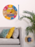 Placa redonda de MDF com 20cm pendurada na parede com um lettering, escrito em branco: Coisas boas levam tempo, com gancho na máquina do relógio para pendurar na parede da casa