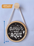 Quadro Decorativo Redondo de Pinus pendurado na parede com gancho de pinus redondo. Enfeite de Parede com frase para família, escrito: O amor mora aqui, feita a mão, com acabamento de corda de algodão
