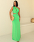Vestido longo verde com detalhe em fenda e torso de um ombro, usado por uma mulher.