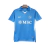 Camisa titular Napoli 2024-2025 azul celeste com mosaico de escudos em embossing. Gola pólo azul com contorno branco e punhos brancos. Nome do time na nuca. Escudo branco no peito esquerdo, logo EA7 branco no direito.