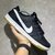 Tênis Nike SB Dunk Preto, em couro, swoosh branco, e o solado bege.