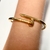 Bracelete dourado de metal em formato de prego
