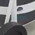 Close-up of a white cart wheel and frame with a "Produto Patentado" sticker on the frame, designed for transporting 5.0 liters cylinders