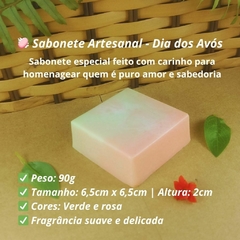 Sabonete artesanal quadrado com 90g nas cores verde e rosa, com aroma suave, apresentado sobre fundo neutro com folha decorativa