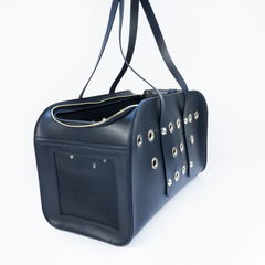 Bolsa importada para transporte de animais de estimação feita em couro com acabamentos dourados.

