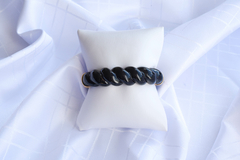 Bracelete torcido em acrilico preto com detalhes em dourado