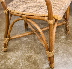 Cadeira de madeira e fibra natural com apoio de braço, refletindo o estilo descontraído de Bali/Asia, disponível na Marcenaria Tiradentes.