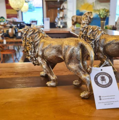 Pequena escultura de leão dourado em resina, perfeita para adicionar elegância e charme a qualquer ambiente de maneira sustentável.