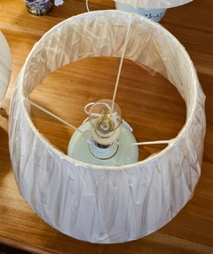 Abajur artesanal em cerâmica azul claro decorado com pássaros verdes e cúpula, ideal para iluminação e decoração sofisticada.