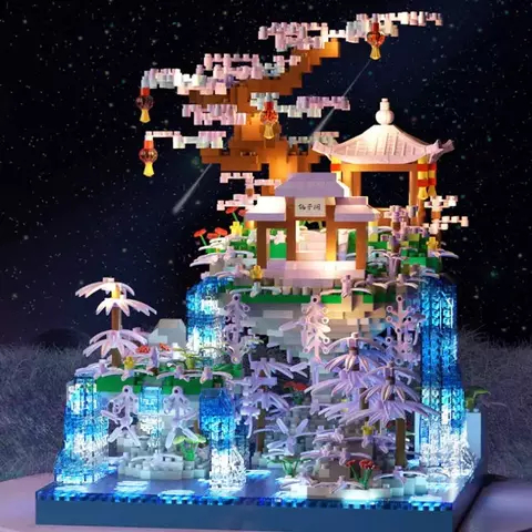 Construcción de un árbol con bloques, con una casa y cascadas iluminadas.
