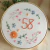 Bordado decorativo com o número 58 e flores coloridas em aro de tecido.