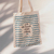 Ecobag com estampa de ondas e a frase "E se não houver vento, reme. No lago e na vida."