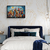 Quarto elegante com cama de cabeceira azul-marinho, decorado com quadro abstrato de cidade colorida em moldura preta. Parede branca com padrão floral dourado, criando contraste com os tons profundos das almofadas e roupa de cama. Luminária pendente modern